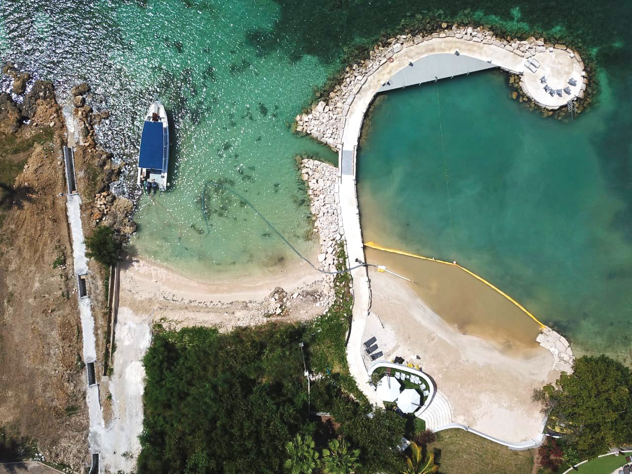 Aerial view of a Type 1 Turbidity Curtain installed along a shoreline restoration area, containing discolored sediment-laden water within a protected coastal work zone.