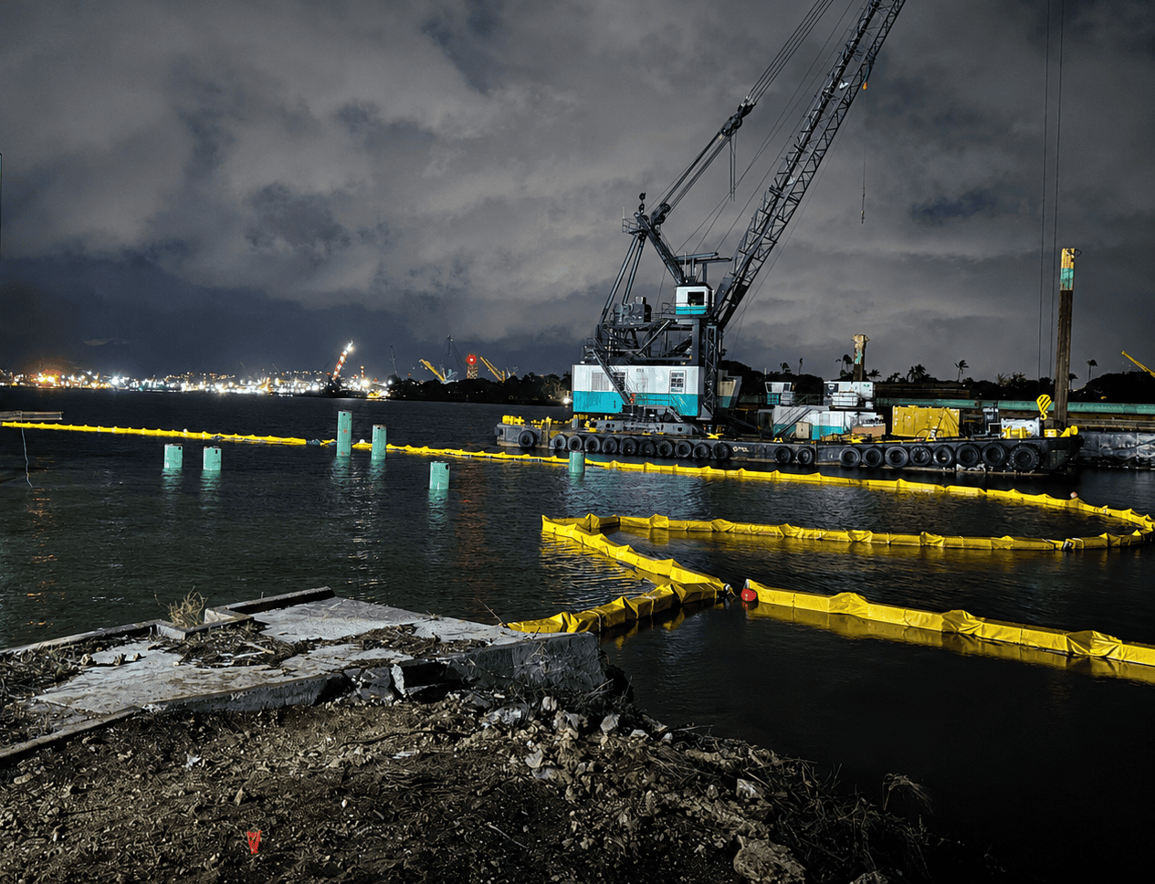 Type 3 turbidity curtain installed around a marine construction area at Pearl Harbor, providing sediment control and water quality protection near a floating crane and dry dock.