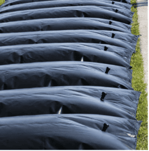 Black dewatering socks installed along a site perimeter to filter sediment-laden water, control runoff, and support erosion and sediment management.