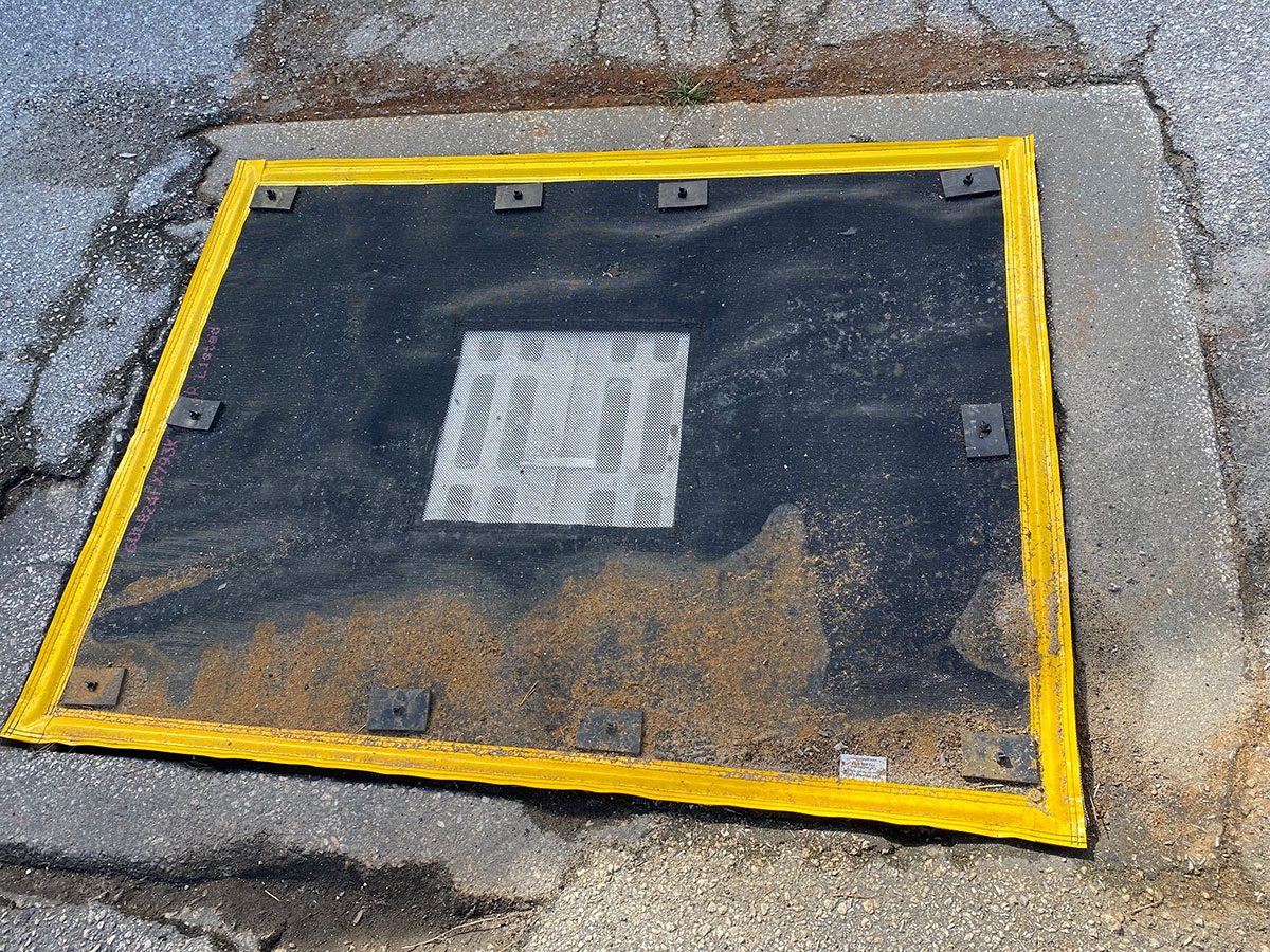 Storm drain inlet protected by an over-the-grate stormwater BMP designed to capture sediment, debris, and pollutants before they enter the drainage system.